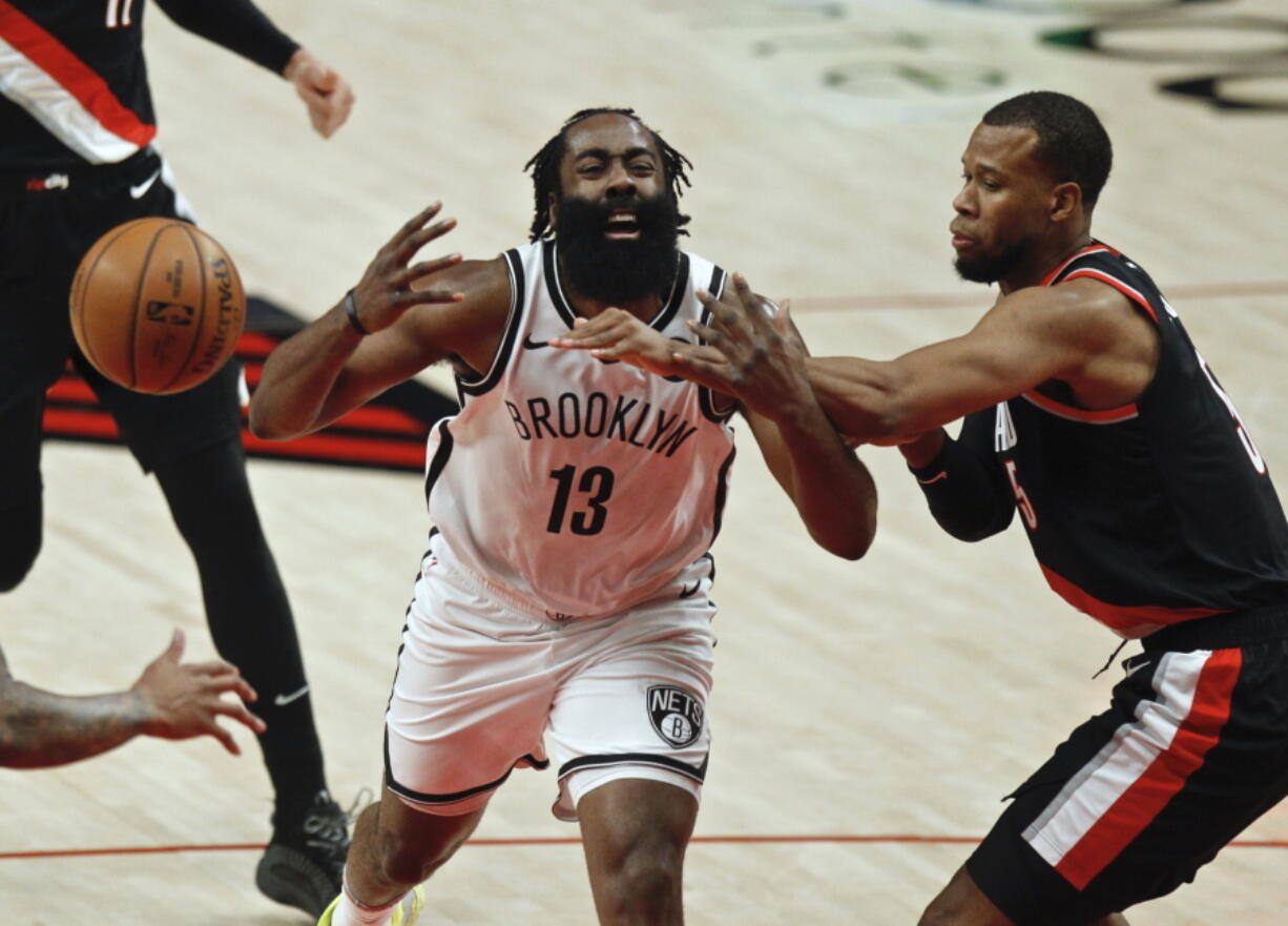 Brooklyn Nets guard James Harden, left, is fouled by Portland Trail Blazers guard Rodney Hood, right, during the first half of an NBA basketball game in Portland, Ore., Tuesday, March 23, 2021.