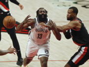 Brooklyn Nets guard James Harden, left, is fouled by Portland Trail Blazers guard Rodney Hood, right, during the first half of an NBA basketball game in Portland, Ore., Tuesday, March 23, 2021.