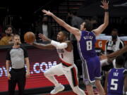 Portland Trail Blazers guard Damian Lillard, left, dives to the basket as Sacramento Kings forward Nemanja Bjelica defends during the first half of an NBA basketball game in Portland, Ore., Thursday, March 4, 2021.