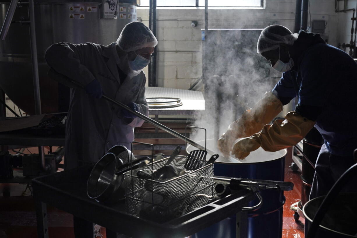 Rabbi Joseph Schwartz, left, and Ryan Eleazar use boiling water to kosherize equipment for the Hanan Products&#039; kosher-for-passover production run Jan. 7 in Hicksville, N.Y.