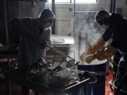 Rabbi Joseph Schwartz, left, and Ryan Eleazar use boiling water to kosherize equipment for the Hanan Products&#039; kosher-for-passover production run Jan. 7 in Hicksville, N.Y.