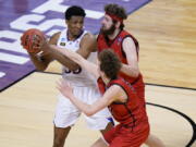 Kansas forward David McCormack, left, is pressured by Eastern Washington forward Tanner Groves, right, and teammate Eastern Jacob Groves, bottom, during the second half of a first-round game in the NCAA college basketball tournament at Farmers Coliseum in Indianapolis, Saturday, March 20, 2021.