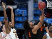 Oregon State guard Ethan Thompson (5) drives to the basket ahead of Loyola Chicago guard Marquise Kennedy (12) during the second half of a Sweet 16 game in the NCAA men&#039;s college basketball tournament at Bankers Life Fieldhouse, Saturday, March 27, 2021, in Indianapolis.