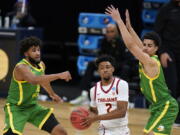 Southern California guard Tahj Eaddy (2) drives between Oregon guard LJ Figueroa, left, and guard Will Richardson, right, during the first half of a Sweet 16 game in the NCAA men&#039;s college basketball tournament at Bankers Life Fieldhouse, Sunday, March 28, 2021, in Indianapolis.