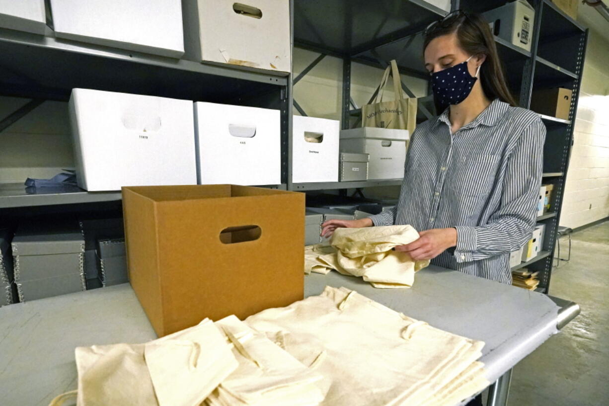 Jessica Walzer, archaeology collections manager with the Mississippi Department of Archives and History, gathers unprovenienced prehistoric pottery and lithics into a hand constructed muslin bag, Friday, March 19, 2021 outside the Two Museums&#039; Archaeology Collections Storage room in Jackson, Miss. Several hundred Chickasaw ancestors and artifacts have been gathered and will soon be returned to native hands to be laid in their final resting place on an undisclosed location in the state. (AP Photo/Rogelio V.