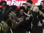 Oregon&#039;s Aaron Estrada, center, and teammates celebrate their team&#039;s win over Oregon State and their second consecutive Pac-12 regular-season conference title following an NCAA college basketball game in Corvallis, Ore., Sunday, March 7, 2021.