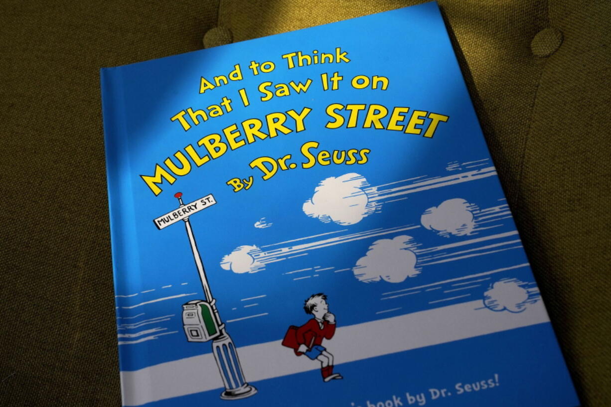 A copy of the book &quot;And to Think That I Saw It on Mulberry Street,&quot; by Dr. Seuss, rests in a chair, Monday, March 1, 2021, in Walpole, Mass. Dr. Seuss Enterprises, the business that preserves and protects the author and illustrator&#039;s legacy, announced on his birthday, Tuesday, March 2, 2021, that it would cease publication of several children&#039;s titles including &quot;And to Think That I Saw It on Mulberry Street&quot; and &quot;If I Ran the Zoo,&quot; because of insensitive and racist imagery.