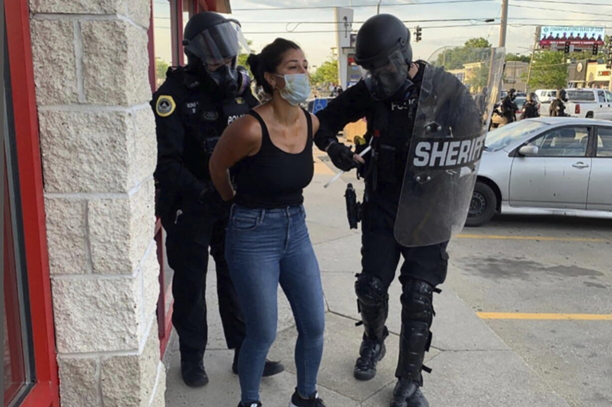 Police officers are shown arresting Des Moines Register reporter Andrea Sahouri after a Black Lives Matter protest she was covering on May 31, 2020, in Des Moines, Iowa, was dispersed by tear gas. Sahouri is set to stand trial on Monday, March 8, 2021, on misdemeanor charges, a case that prosecutors have pursued despite international condemnation from advocates for press freedom.