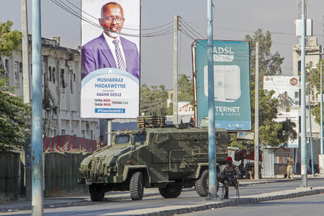 Security forces block a street with an armored personnel carrier during protests against the government and the delay of the country&#039;s election in the capital Mogadishu, Somalia Friday, Feb. 19, 2021.  Security forces in Somalia&#039;s capital fired on hundreds of people protesting the delay of the country&#039;s election on Friday as at least one explosion was reported at the international airport and armored personnel carriers blocked major streets.