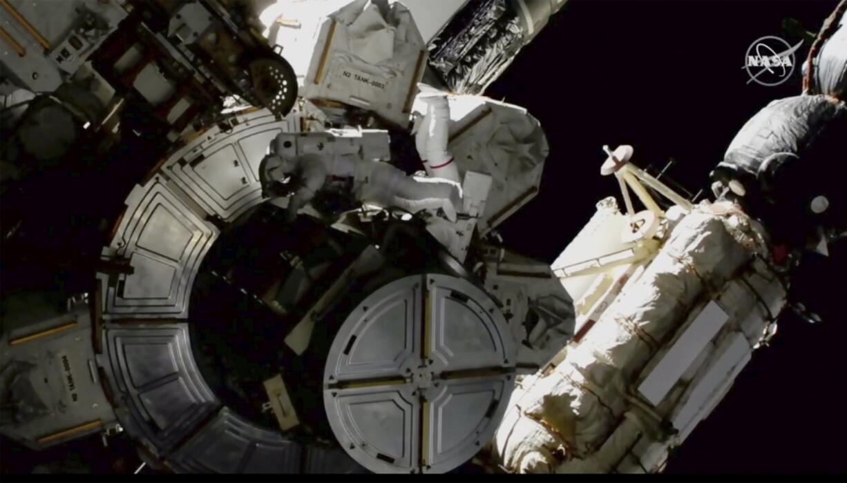 NASA astronauts Victor Glover and Mike Hopkins on a spacewalk outside the International Space Station on Saturday. The astronauts are rearranging space station plumbing and tackling other odd jobs.