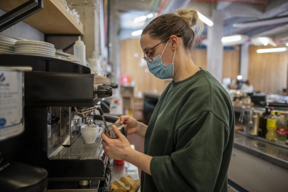 Waiter Sara Palacios prepares a coffee as she works at La Francachela restaurant in Madrid, Spain, Friday, March 26, 2021.