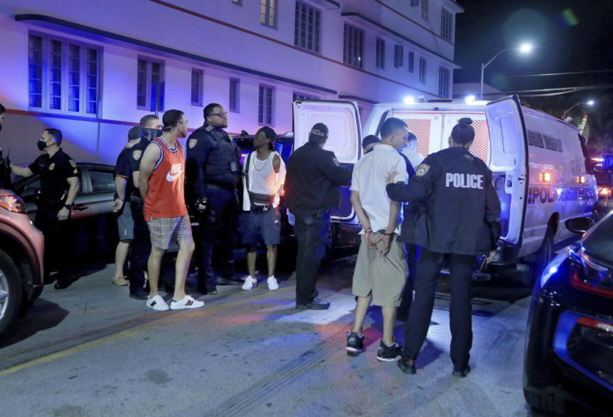 City of Miami Beach Police officers arrest several males on Ocean Drive and 10th Street as spring break has officially begun Saturday, Feb. 20, 2021 in Miami Beach, Fla. Miami Beach officials are imposing an emergency 8 p.m.-6 a.m. curfew effective immediately, saying large, out-of-control spring break crowds crammed the beaches, trashed some restaurant properties and brawled in the streets. Tourists and hotel guests are being told to stay indoors during the curfew hours.