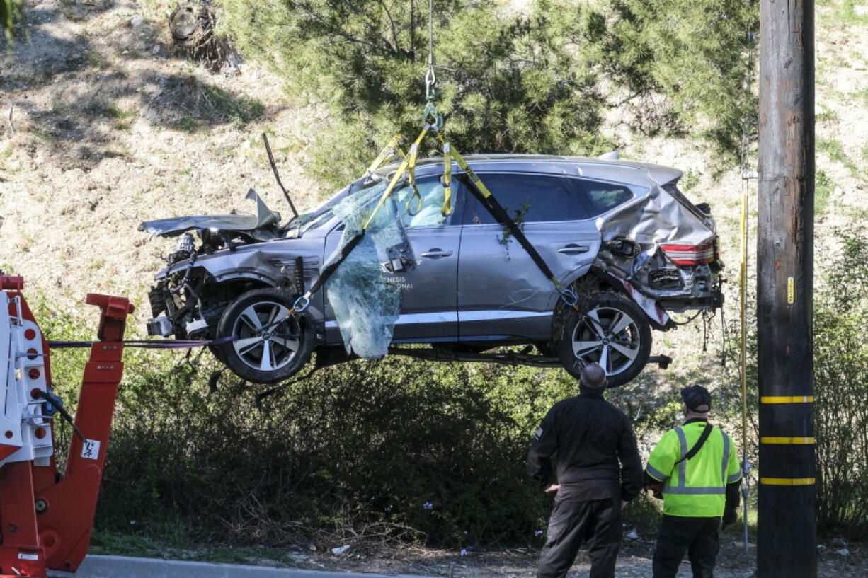 FILE - In this Feb. 23, 2021, file photo, a crane is used to lift a vehicle following a rollover accident involving golfer Tiger Woods, in the Rancho Palos Verdes suburb of Los Angeles. Detectives are looking at data from the so-called &quot;black box&quot; of Tiger Woods&#039; SUV to get a clearer picture of what occurred during the Southern California rollover crash last week that seriously injured the golf star, authorities said Wednesday, March 3. (AP Photo/Ringo H.W.