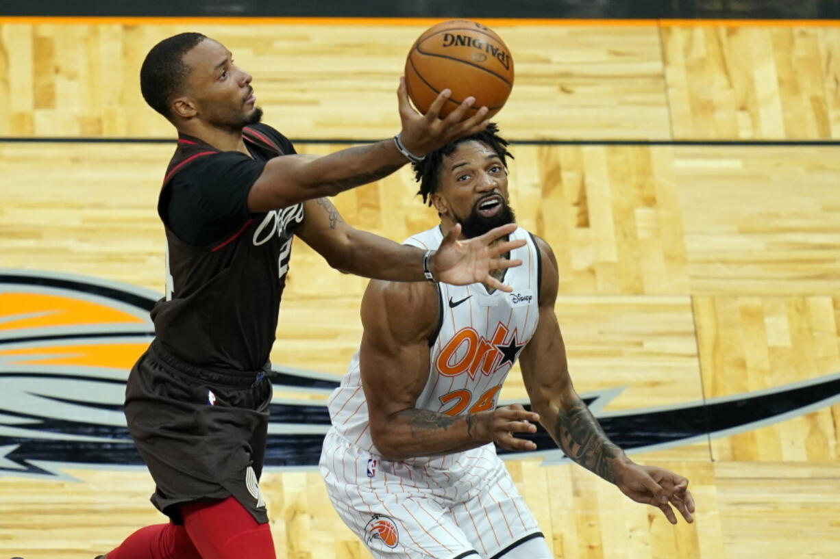 Portland Trail Blazers Norman Powell, left, goes up to shoot past Orlando Magic center Khem Birch during the first half of an NBA basketball game, Friday, March 26, 2021, in Orlando, Fla.