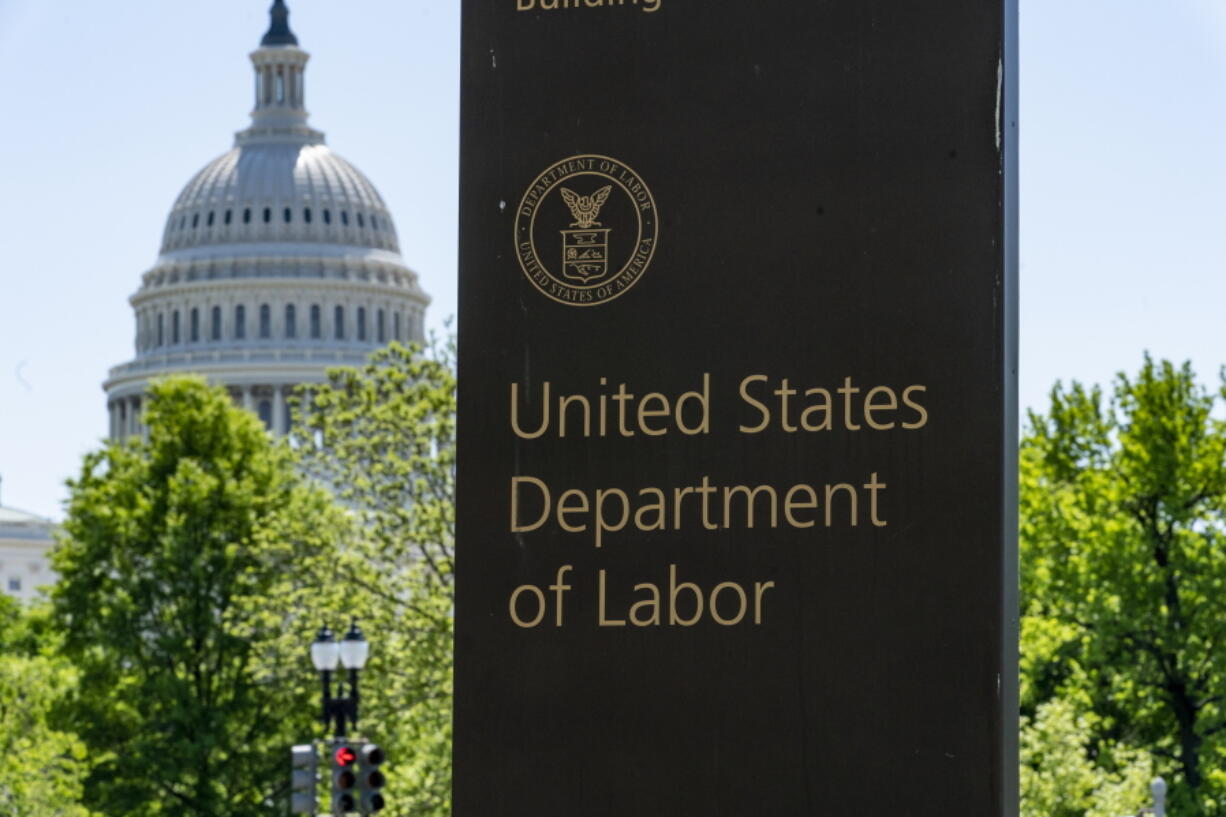 FILE - In this May 7, 2020, file photo, the entrance to the Labor Department is seen near the Capitol in Washington. Unemployment fraud in the U.S. has reached dramatic levels during the pandemic: more than $63 billion has been paid out improperly through fraud or errors since March 2020. Criminals are seizing on the opportunity created by the pandemic and are making false claims using stolen information. (AP Photo/J.