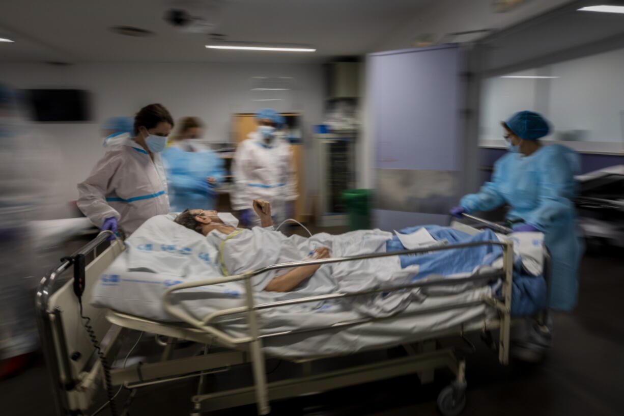 FILE - In this Feb. 17, 2021, file photo, a COVID-19 patient is transferred to the &quot;red zone,&quot; an area reserved for treating those suffering from COVID-19, in the Severo Ochoa Hospital in Leganes on the outskirts of Madrid, Spain. Optimism is spreading in the U.S. as COVID-19 deaths plummet and states ease restrictions and open vaccinations to younger adults. But across Europe, dread is setting in with another wave of infections that is closing schools and cafes and bringing new lockdowns.