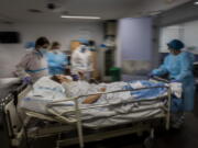 FILE - In this Feb. 17, 2021, file photo, a COVID-19 patient is transferred to the &quot;red zone,&quot; an area reserved for treating those suffering from COVID-19, in the Severo Ochoa Hospital in Leganes on the outskirts of Madrid, Spain. Optimism is spreading in the U.S. as COVID-19 deaths plummet and states ease restrictions and open vaccinations to younger adults. But across Europe, dread is setting in with another wave of infections that is closing schools and cafes and bringing new lockdowns.