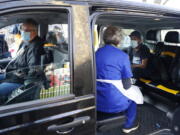 Dr Tamara Joffe prepares to administer a Covid-19 jab using the AstraZeneca vaccine to Leslie Reid in the back of a London Taxi cab during the pilot project of pop up vaccination drive &#039;Vaxi Taxi&#039; in Kilburn, London, Sunday, Feb. 28, 2021. The pilot scheme, funded by the Covid Crisis Rescue Foundation, aims to help ferry supplies and patients to temporary clinics set up in faith and community centres across the capital. People don&#039;t even need to leave the backseat if they didn&#039;t want to in order to receive their inoculation.