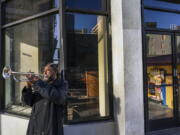 FILE - In this Feb. 5, 2021, file photo, street musician Roberto Hernandez, originally from El Salvador, plays &quot;Lambada&quot; on his trumpet outside Buddy&#039;s, a restaurant temporarily closed due to the COVID-19 pandemic, in downtown Los Angeles. Los Angeles County could move into the next phase of reopening with fewer restrictions as early as next week, though any actual lifting of coronavirus-related constraints would not happen immediately, health officials said Wednesday, March 3, 2021.