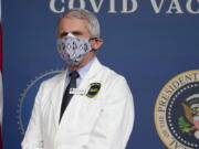 FILE - In this Feb. 25, 2021, Dr. Anthony Fauci, director of the National Institute of Allergy and Infectious Diseases, listens as President Joe Biden speaks during an event to commemorate the 50 millionth COVID-19 shot in Washington.  Fauci said Sunday, March 14,  he wishes former President Donald Trump would use his popularity among Republicans to persuade his followers to get the COVID-19 vaccine. In a round of interviews on the morning news shows, Fauci lamented polling showing that Trump supporters are more likely to refuse to get vaccinated, saying politics needs to be separated from &quot;commonsense, no-brainer&quot; public health measures.