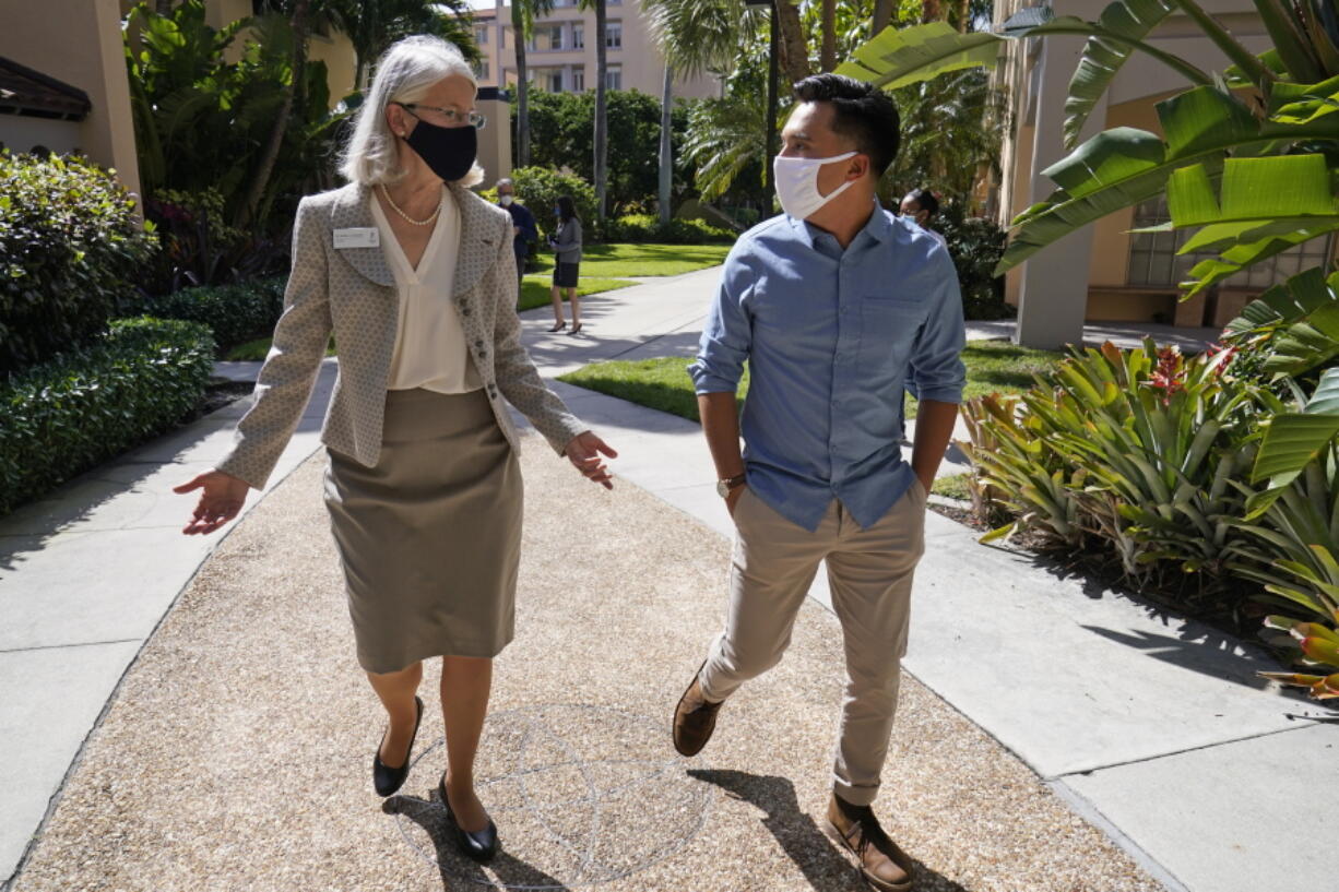 Palm Beach Atlantic University&#039;s new president Dr. Debra Schwinn, left, chats with Pablo Castillo, a senior business major from Guatemala City, Friday, Feb. 26, 2021, as they walk on campus in West Palm Beach, Fla. Every day at 5 p.m., no matter what Schwinn is doing, she jumps on a Zoom call with students in coronavirus quarantine, one of which was Castillo in September after being exposed to COVID-19. Schwinn said she tries on the calls to help students find a way to remain positive in an admittedly bad circumstance.