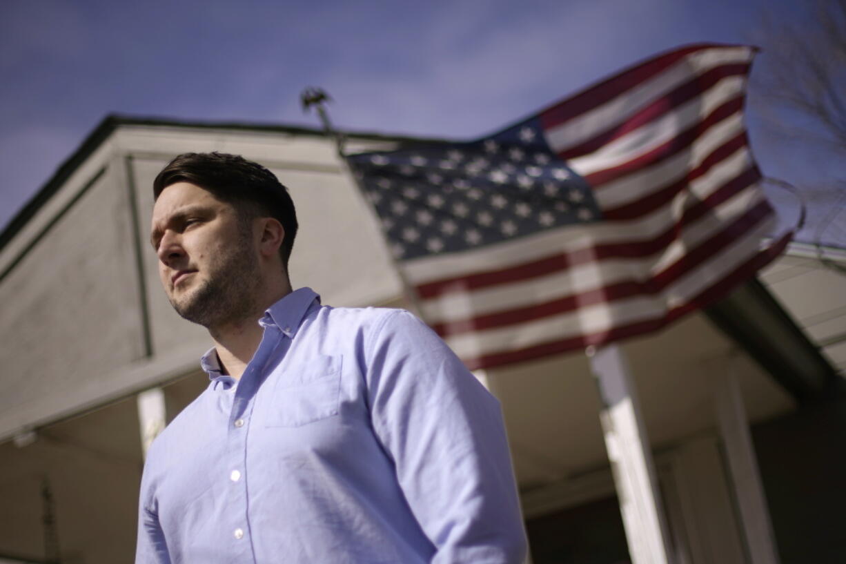 Logan DeWitt stands outside his home Monday, March 8, 2021, in Kansas City, Kan. Because he could work at home, Logan kept his job through the pandemic while his wife lost hers and went back to school. Their financial situation was further complicated with the birth of their daughter nine months ago.