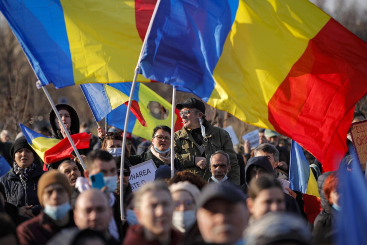 Anti-vaccination protesters rally outside the parliament building in Bucharest, Romania, Sunday, March 7, 2021. Some thousands of anti-vaccination protestors from across Romania converged outside the parliament building protesting against government pandemic control measures as authorities announced new restrictions amid a rise of COVID-19 infections.