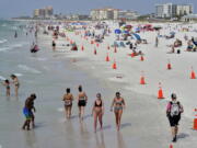 Beachgoers take advantage of the weather as they spend time on Clearwater Beach Tuesday, March 2, 2021, in Clearwater, Fla., a popular spring break destination, west of Tampa. Colleges around the U.S. are scaling back spring break or canceling it entirely to discourage beachfront partying that could raise infection rates back on campus.