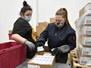 Employees with the McKesson Corporation scan a box of the Johnson &amp;  Johnson COVID-19 vaccine while filling an order at their shipping facility in Shepherdsville, Ky., Monday, March 1, 2021. (AP Photo/Timothy D.