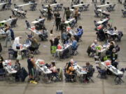 Patients are given the first dose of the Pfizer COVID-19 vaccine, Saturday, March 13, 2021, on the first day of operations at a mass vaccination site at the Lumen Field Events Center in Seattle, which adjoins the field where the NFL football Seattle Seahawks and the MLS soccer Seattle Sounders play their games. The site, which is the largest civilian-run vaccination site in the country, will operate only a few days a week until city and county officials can get more doses of the vaccine. (AP Photo/Ted S.