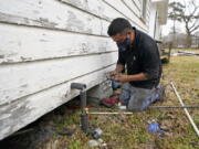 West Street Recovery&#039;s Johnny Vicar works to repair busted pipes under a home, that were frozen during the recent winter storm, Thursday, Feb. 25, 2021, in Houston. West Street Recovery, a nonprofit created in the wake of Hurricane Harvey to help repair flood damaged homes, has been working since the winter storm hit to repair and replace damaged plumbing systems for residents who can&#039;t afford to do so. (AP Photo/David J.