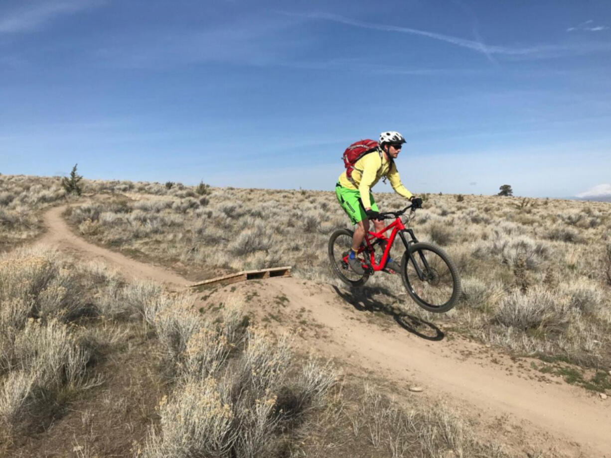 Andrew Williams, of Bend, flies off a jump feature at the Madras East Hills trail system on Sunday.