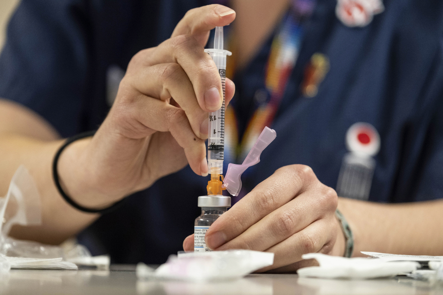 A pharmacist prepares an injection of the Moderna COVID-19 vaccine in Seattle.