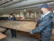 Architects of the Capitol staff hold rare century-old mahogany obtained from a U.S. Forest Service lab storage locker in Wisconsin. This historic mahogany lumber, received from USDA Forest Service's Forest Products Laboratory, will be used to replace U.S. Capitol doors and other wood details damaged during the January 2021 breach.