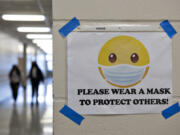 A sign encourages students and staff to wear their masks in a hallway at Heritage High School on March 4.