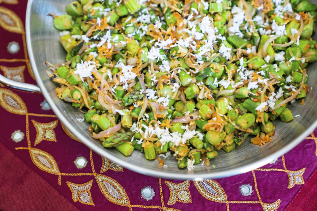 Sliced asparagus are stir-fried with fresh coconut, shallots and cloves photographed on Friday, March 19, 2021, in Oakmont.  They get a slight and delightful kick from a chutney powder that is added toward the end.