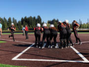 Battle Ground softball players greet Candice Adams at home plate after she hit a grand slam in the Tigers' 17-4 win over Camas on Wednesday at Camas High School (Micah Rice/The Columbian).