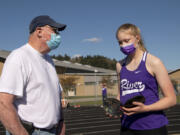 Columbia River volunteer coach Rick Sloan instructs freshman Logan DeJong, his eldest granddaughter, during a 2A Greater St. Helens League meet at Woodland High School. Sloan, 74, was a participant at the 1968 Summer Olympics in Mexico City, placing seventh in the decathlon. He went on to have a 41-year coaching career at Washington State.