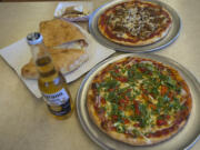 The Punjabi special, clockwise from bottom, a calzone with pepperoni and a NYC pizza is pictured at N.Y.C. Pizzeria on Friday afternoon, April 26, 2019.