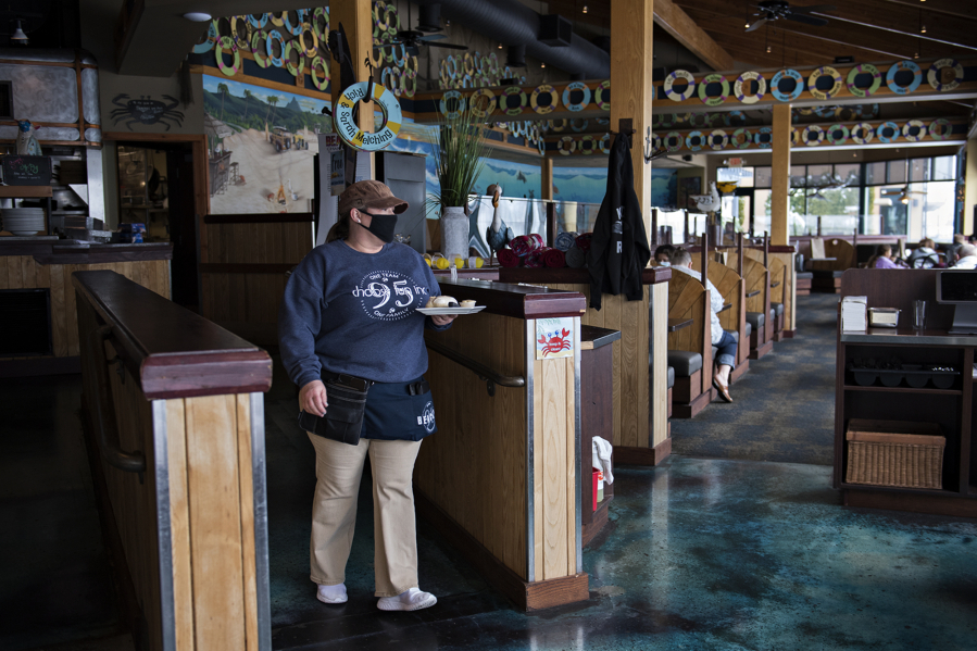 Beaches server April Martinell brings a plate of bread to customers. Restaurants returned to limited indoor dining in February.