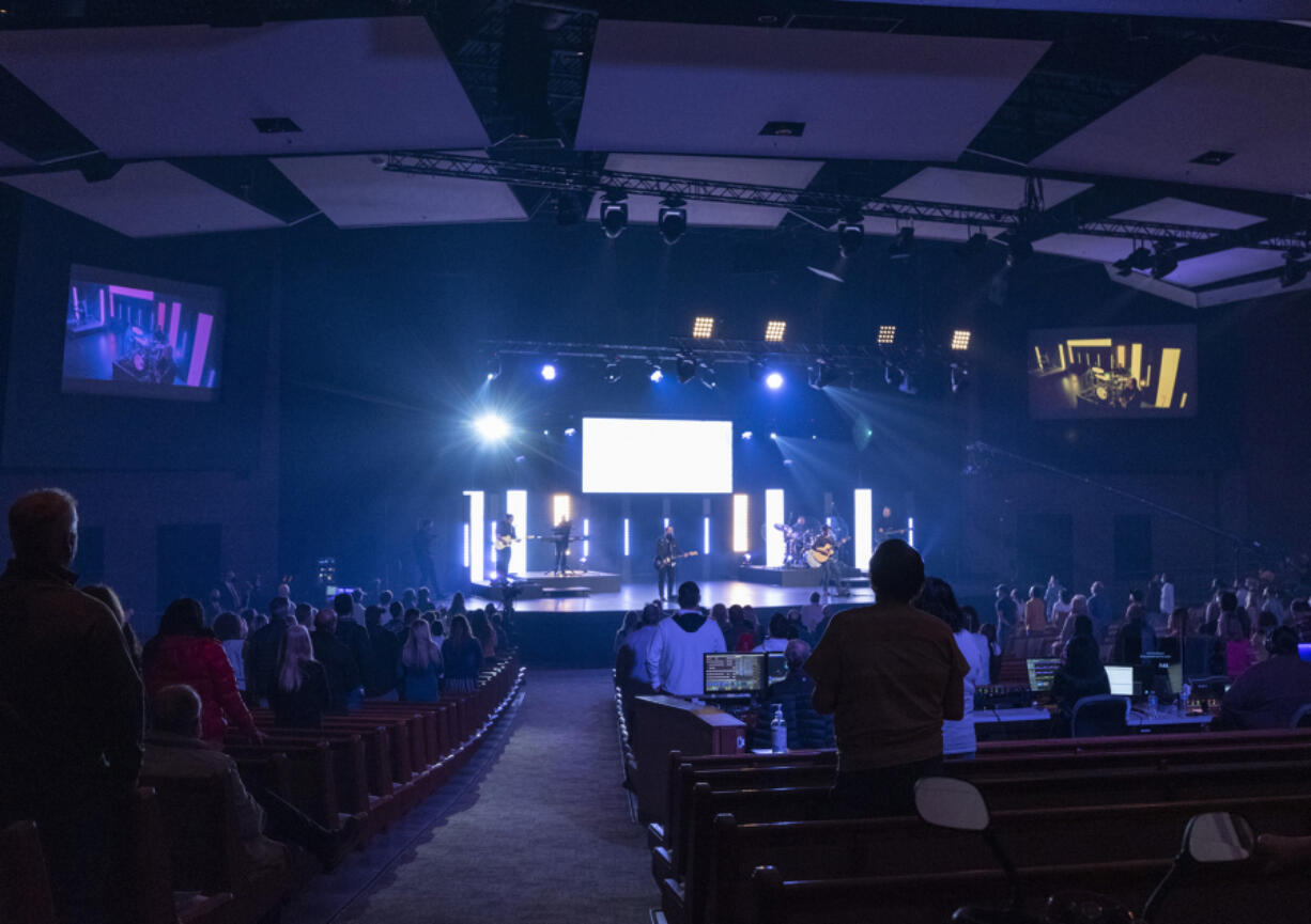 Blue lights illuminate a rocking Palm Sunday service and reduced-capacity congregation at Crossroads Community Church.