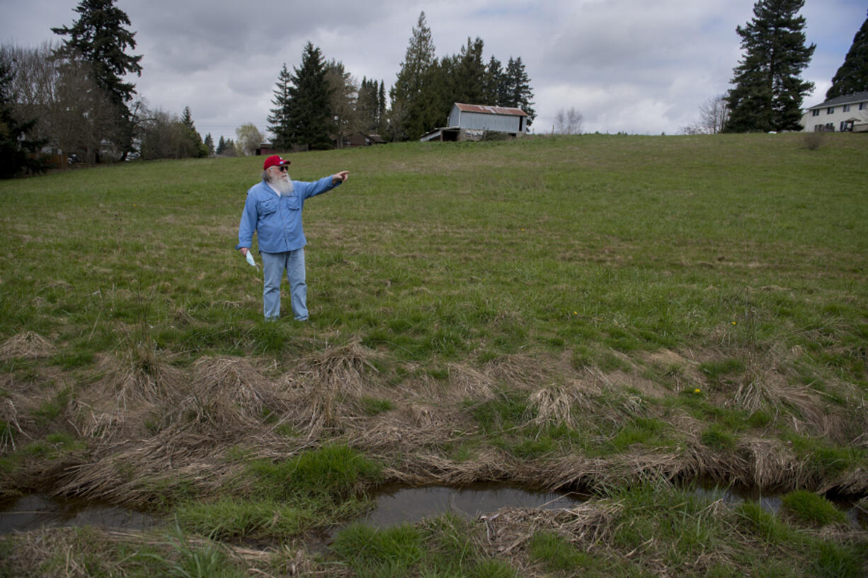 Tom Hill looks over vacant land on March 30 that is the site of a future apartment complex in the Northeast Hazel Dell neighborhood. Residents say the project will cause major traffic headaches in the area. A small stream that feeds into Tenny Creek is seen nearby.