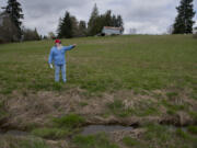 Tom Hill looks over vacant land on March 30 that is the site of a future apartment complex in the Northeast Hazel Dell neighborhood. Residents say the project will cause major traffic headaches in the area. A small stream that feeds into Tenny Creek is seen nearby.