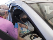 Safeway pharmacist Kristen Morin administers a dose of vaccine to Carol Hoak of Vancouver.