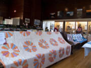 Quilts line the pews on Saturday at the North Clark Historical Museum in Amboy. This quilt pictured was recently donated by 101-year-old Elaine Fletcher. Her mother crafted the mostly finished quilt; a needle was found in the unfinished binding.