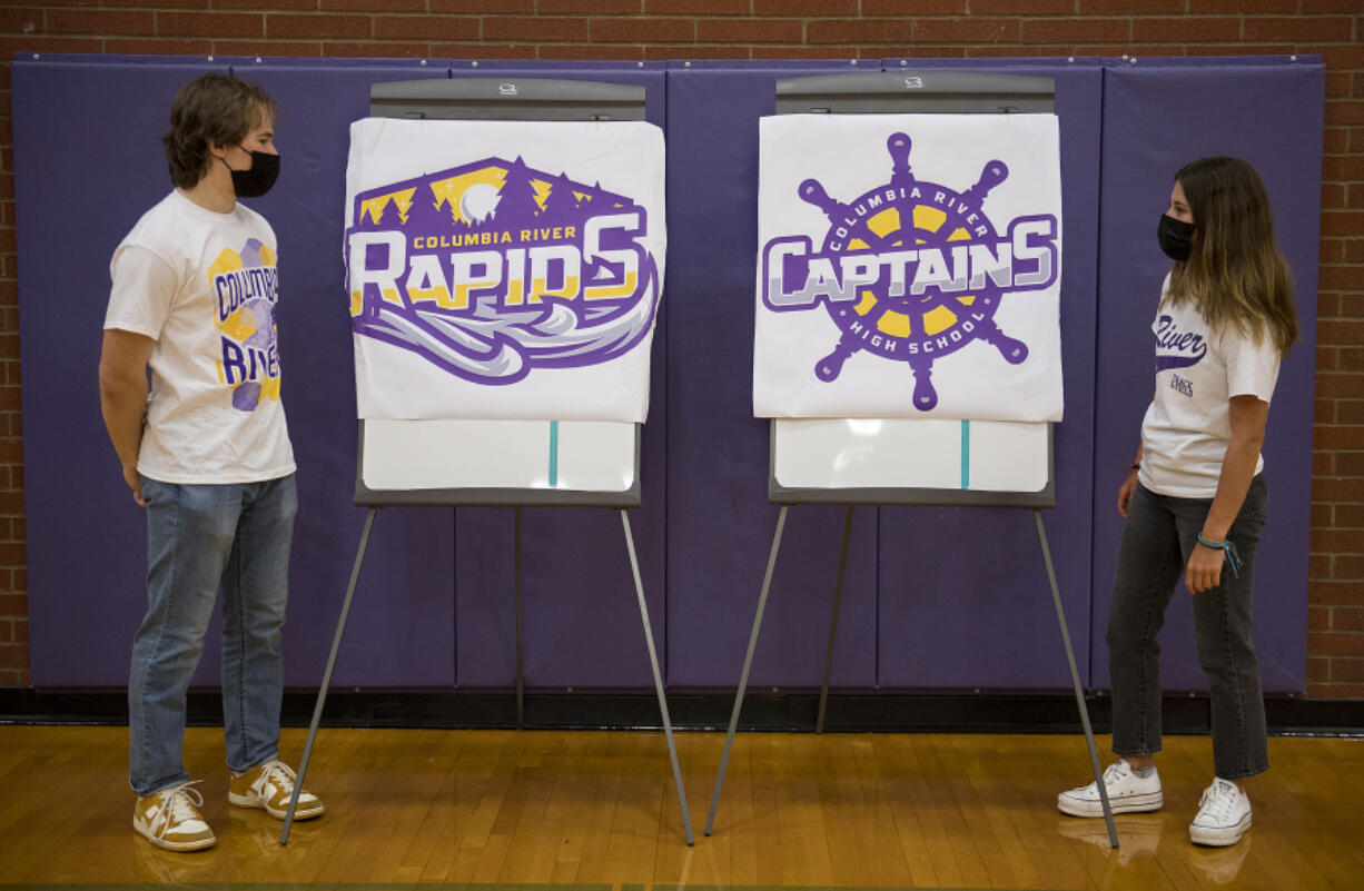 Columbia River High School seniors Keith Blau, 18, and Luci Ianello, 17, look over choices for the school&#039;s new mascot, the Rapids or the Captains, while pausing for a photo in the school&#039;s gym.