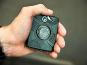 Officer Ryan Snider holds a body camera used by the Spokane Police Department in 2016.