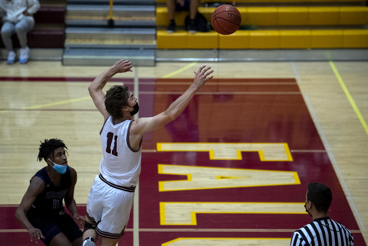 Prairie’s Reece Walling jumps to save a ball from going out of bounds while Heritage’s Jalen Hinton watches in a 4A/3A Greater St. Helens League boys basketball game on Tuesday, April 20, 2021 at Prairie High School. The Falcons won 74-61.