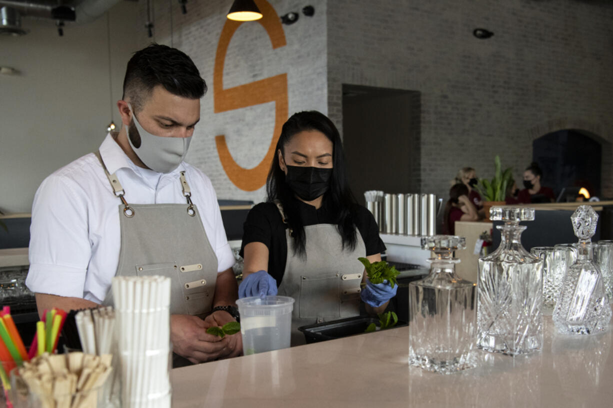 Bartender Kegan Duz-Aguilar and bar manager Oula Thepsouvanh prepare mint leaves for the afternoon rush at Saap Fusion Kitchen at Grand Central Retail Center in Vancouver. The restaurant recently opened in the space formerly occupied by Lapellah and has been transformed thanks to $500,000 in renovations.