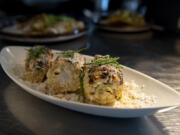 A corn-on-the-cob plate sits under a warming lamp at Saap Fusion Kitchen at Grand Central Retail Center in Vancouver. The restaurant recently opened and serves a menu with Spanish-Asian influences accessible to many dietary preferences.